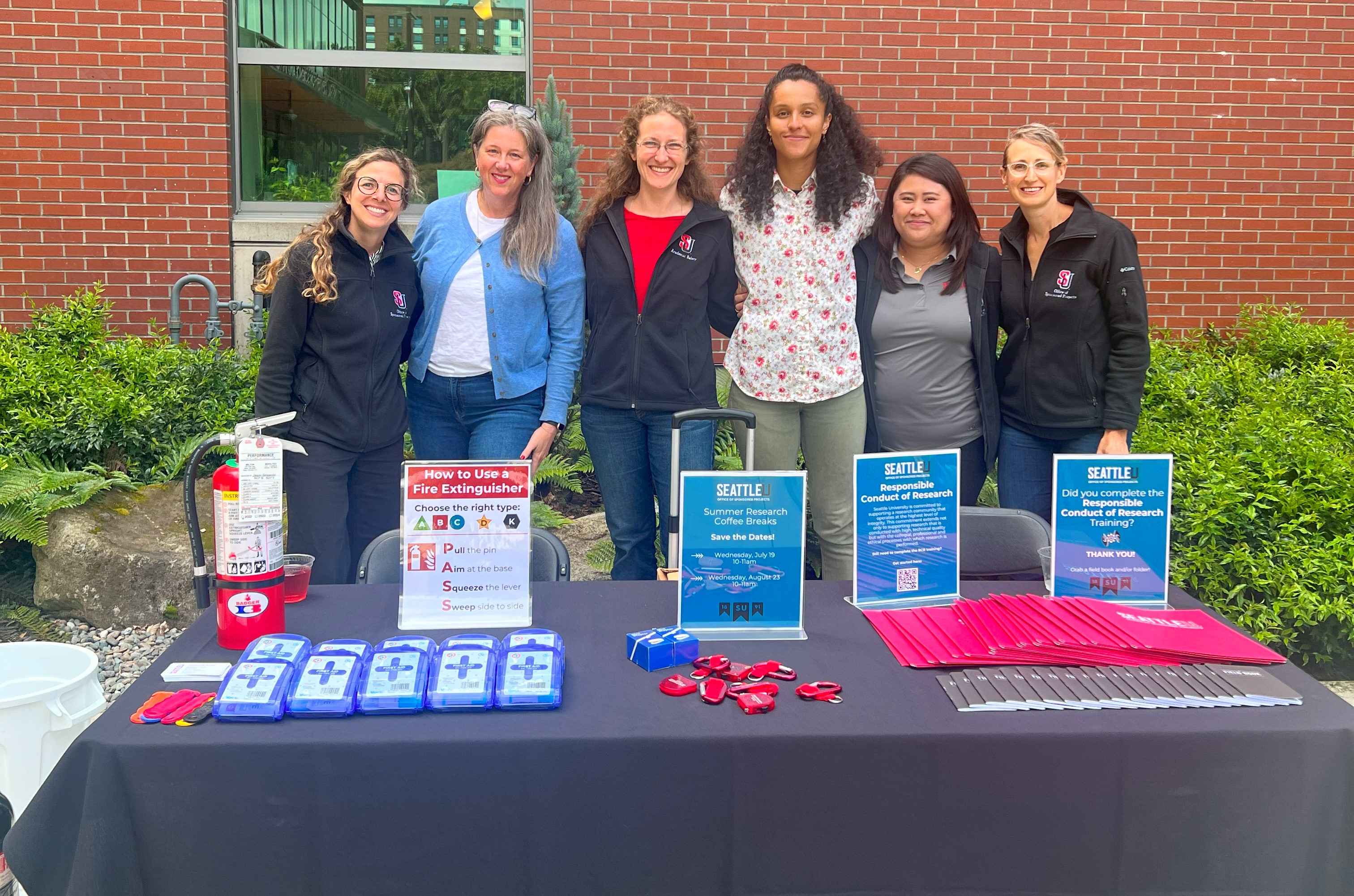 OSP team members posing for a photo behind a table of resources