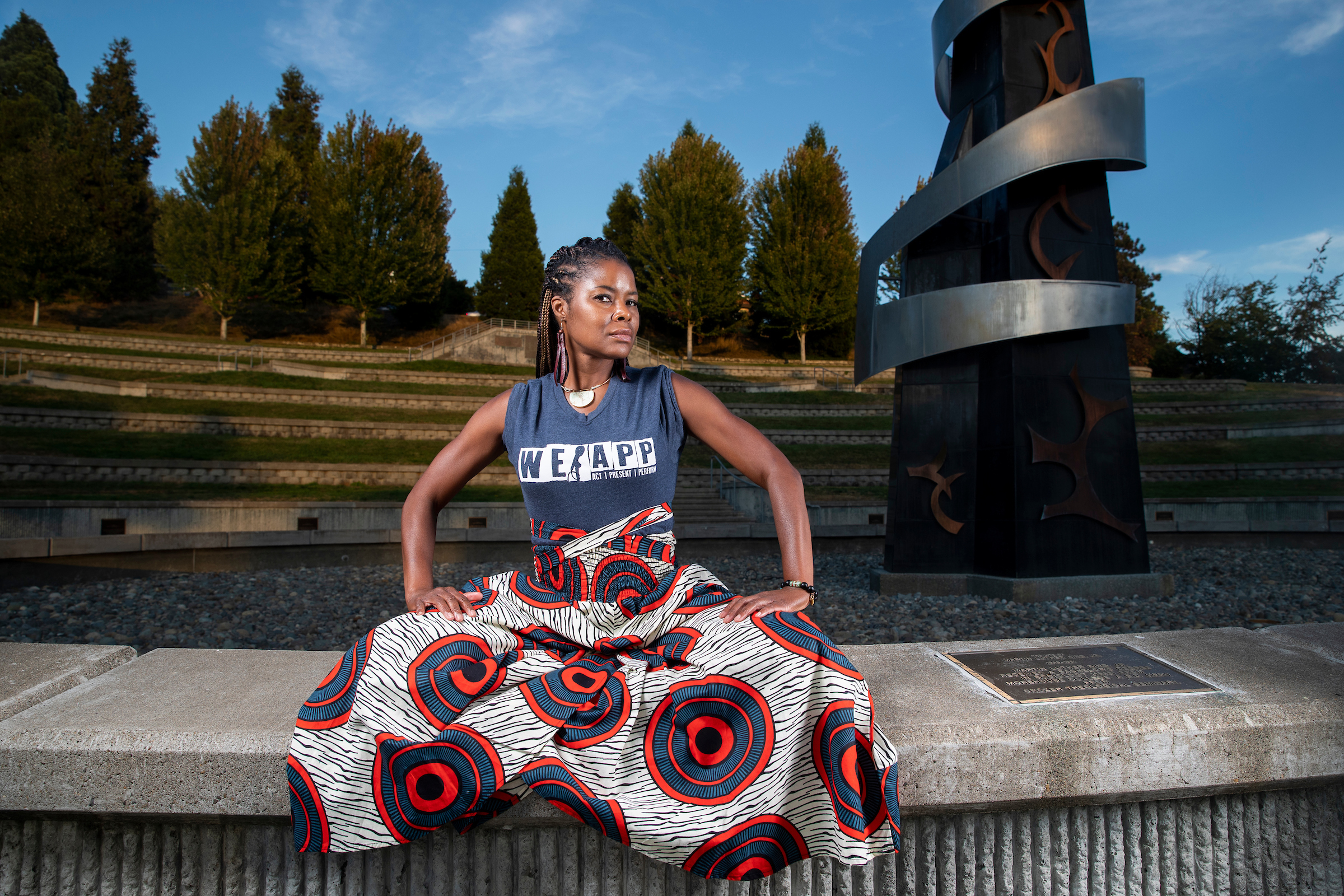 MFA student  with We App uniform sitting in the ground, posing for the photo