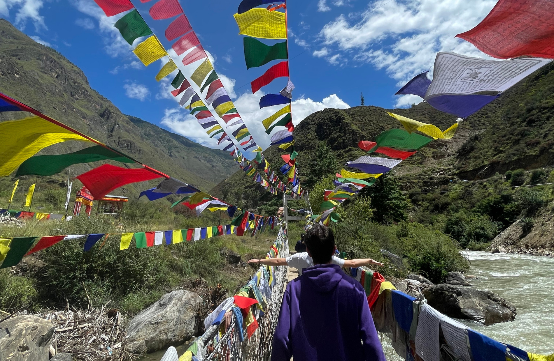 people walking away on a bridge decorated with flags