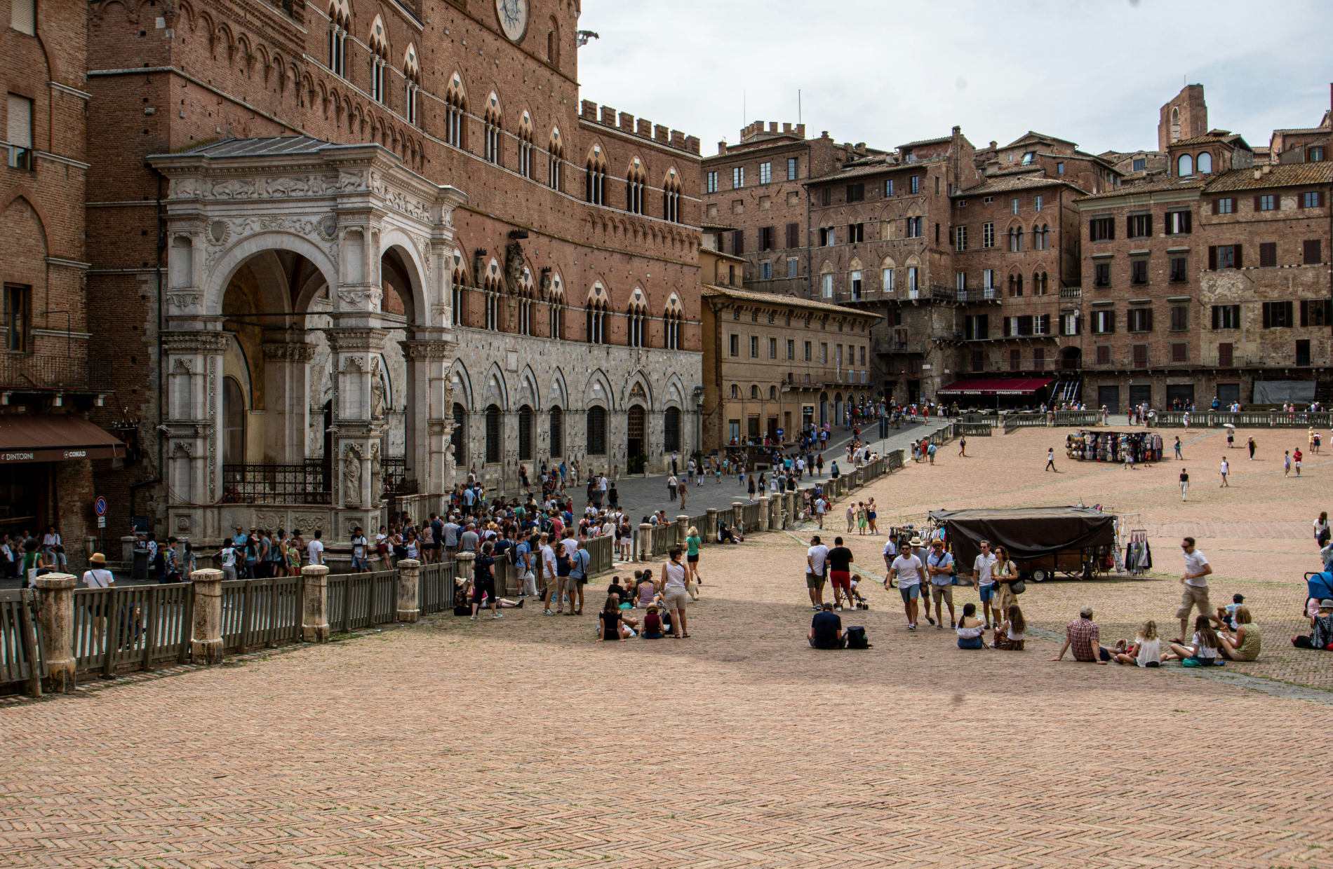 people relaxing in a large Italian plaza surrounded by buildings