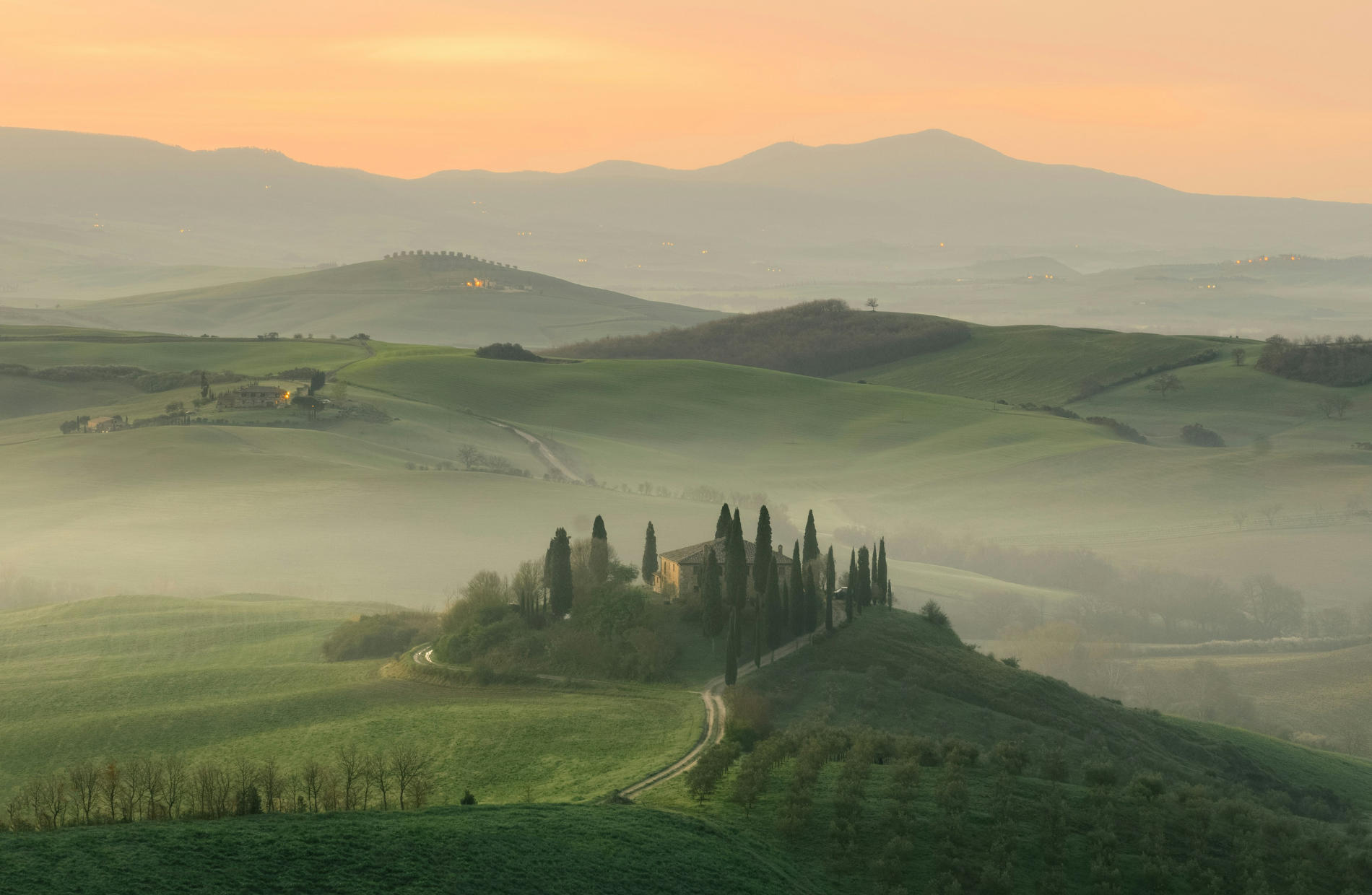 foggy overhead shot of Tuscan countryside with houses on the hills