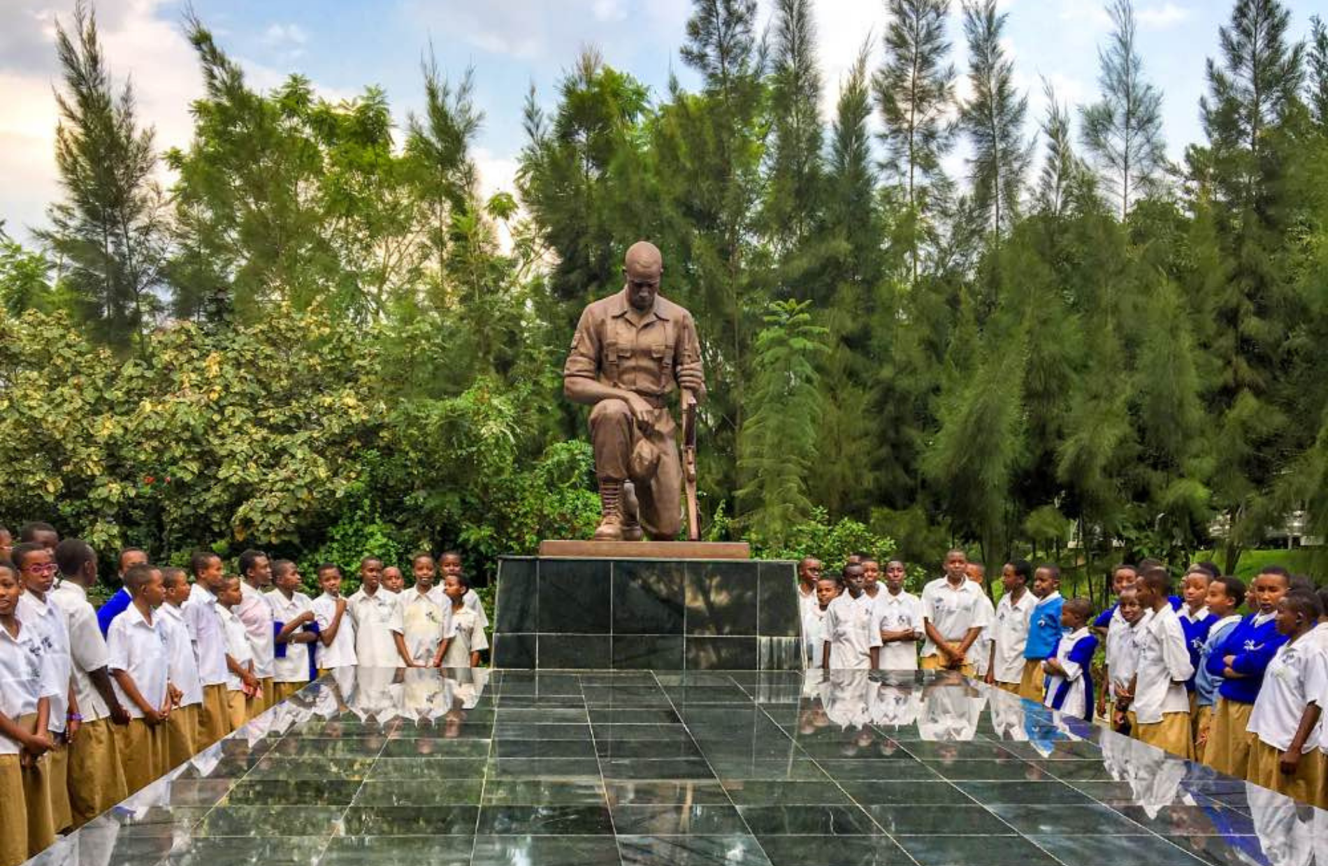 students around a monument of a kneeling solider