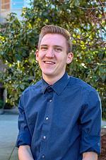 Photo of Brandon Bassler in front of trees