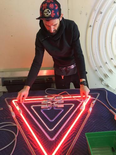 Photo of Dylan Neuwirth working neon art