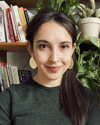 Photo of Mariah Ribeiro in front of book case