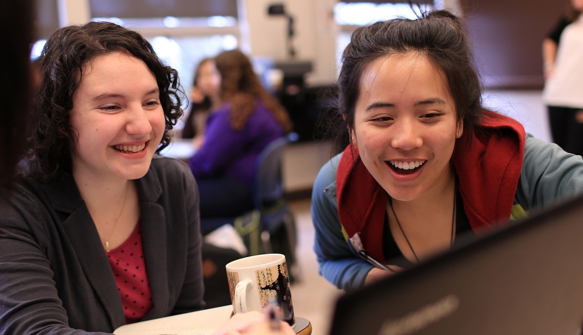 Two women student look at a computer