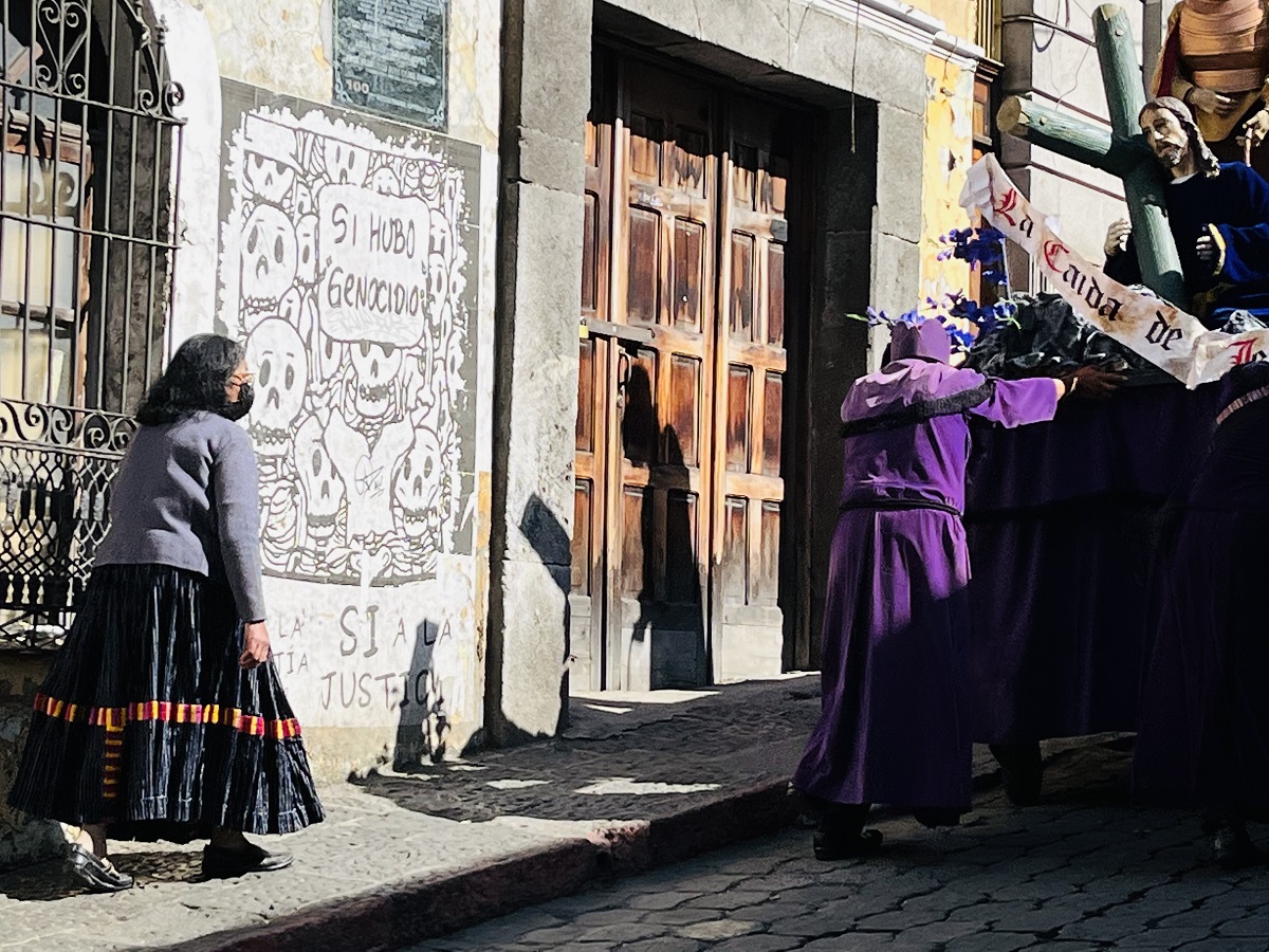 Photo of artwork on wall and people in procession