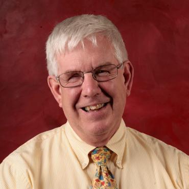 Photo of Dave Madsen in front of red background