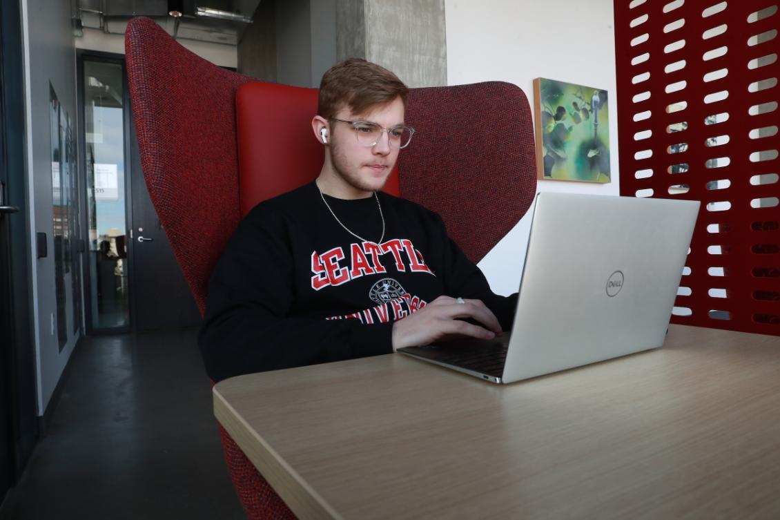 A man sitting at a table with a laptop.