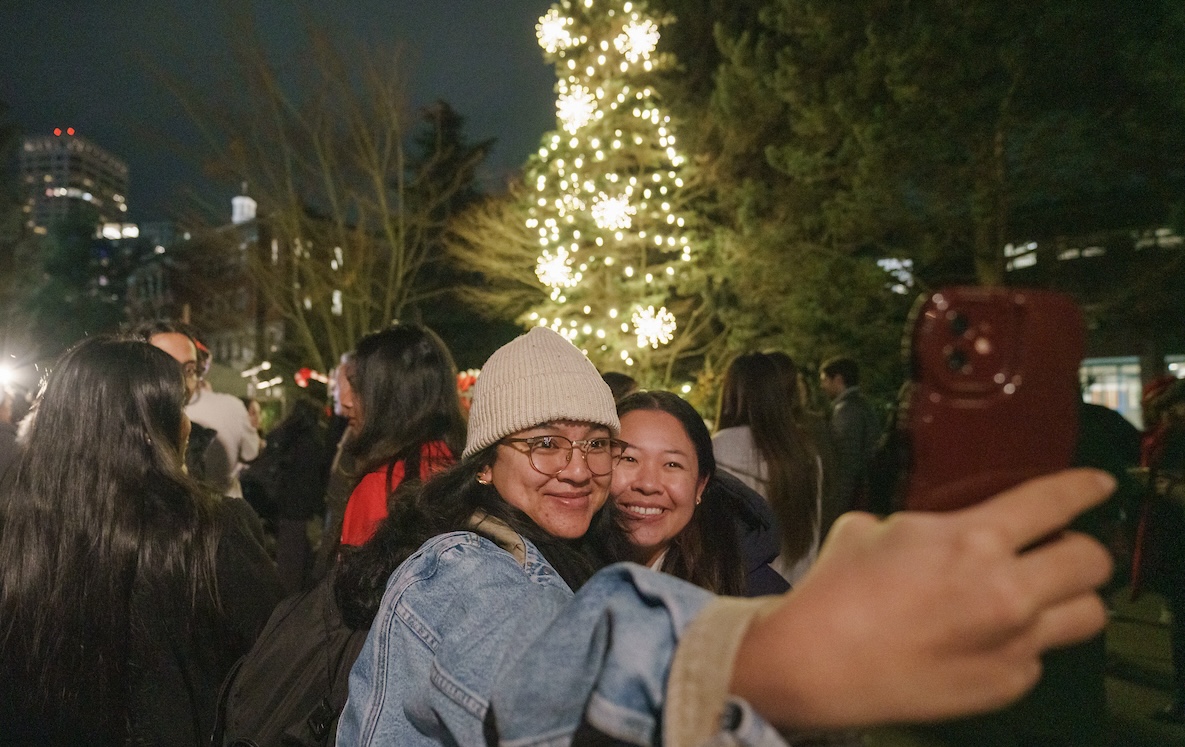 Students in front of lit tree