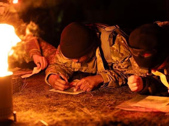 ROTC cadet writing on ground