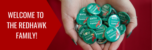 Image of hands holding welcome to the redhawk family pins