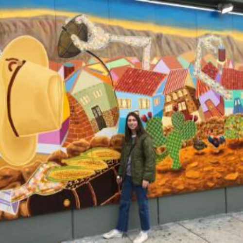 Photo of Austin Nelson in front of a colorful mural