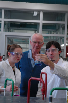 Don working with chemistry students in a lab.