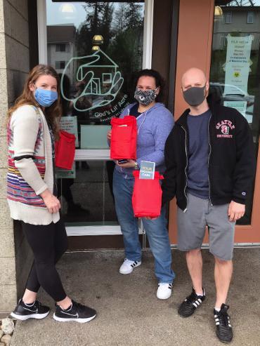 Sarah and Brad wearing masks and holding up medical kits.