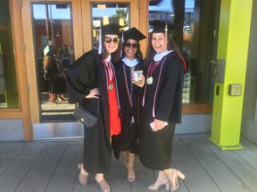 A photo of three women wearing graduation robes