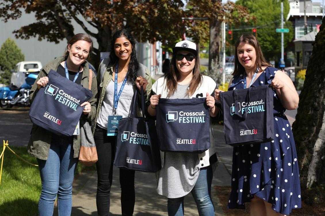 a group of women holding crosscut and Seattle University drawstring bags