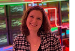 A profile photo of Katie standing in front of neon lights