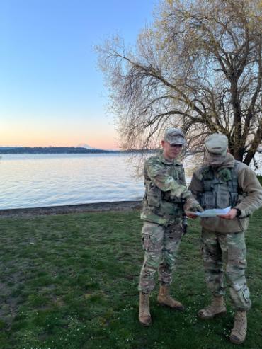 two cadets outside with Puget Sound & Mt Rainier in distance