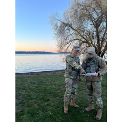 two cadets outside with Puget Sound & Mt Rainier in distance