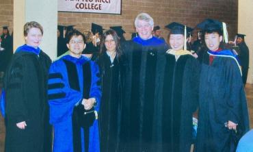 Paul Milan (center) and colleagues at SU commencement