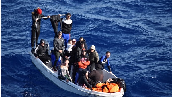 Group of refugees in small boat at sea