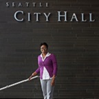 Karinda Harris, woman standing in front of City Hall sign.