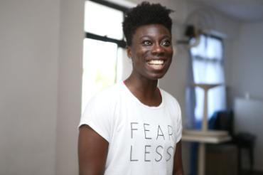 Photo of Nikki Yeboah smiling and wearing a shirt that says 