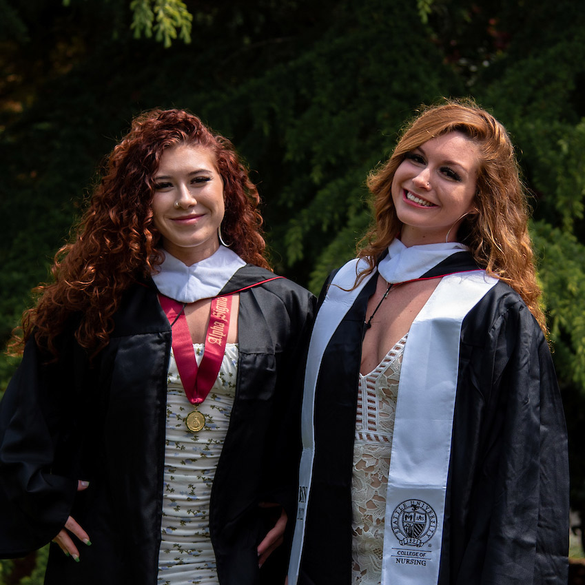 Amber Rodriguez-Munoz and Eva Rodriguez standung together in thier commencement gowns