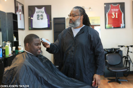 Earl Lancaster giving a trim to Cameron Dollar, Seattle University’s head coach of men’s basketball
