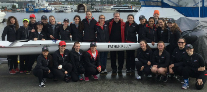 Group photo of the Women's Crew Team and Father Kelly