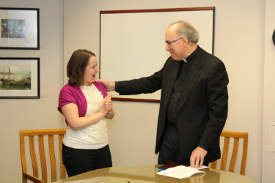 Laura Hauck-Vixie reacts as Fr. Steve informs her she will receive the 2015 Excellence in Staff Leadership Award