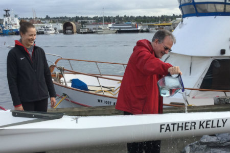 Father Kelly christening a rowing shell
