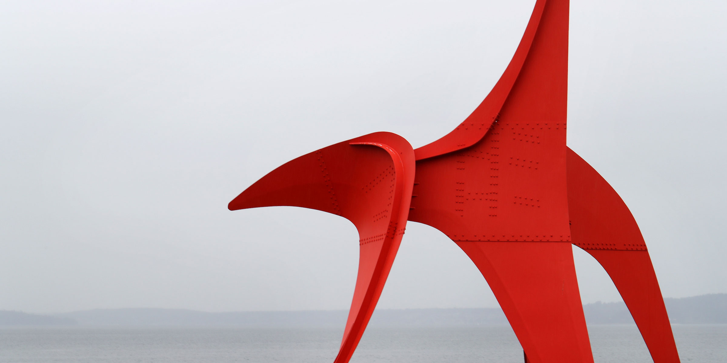a red painted steel sculpture by Calder - a Seattle icon on the waterfront on a grey day
