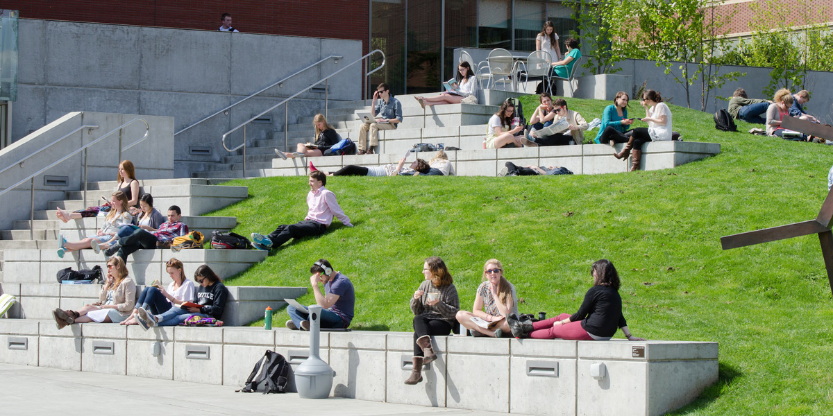 students studying outside Lemieux Library on a sunny Spring day