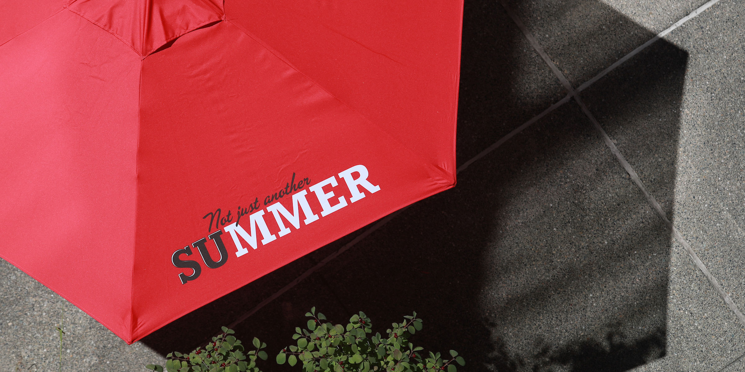 birds eye view of a bright red patio umbrella that reads SU Summer