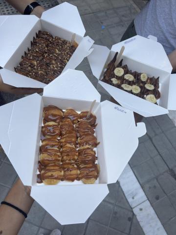 three boxes of mini pancakes with nutella and dulce de leche toppings