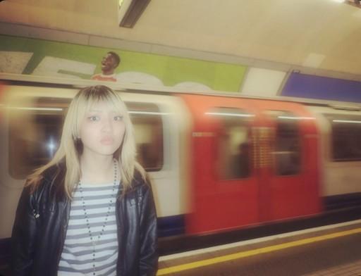 Woman standing on a platform with a train going by behind her