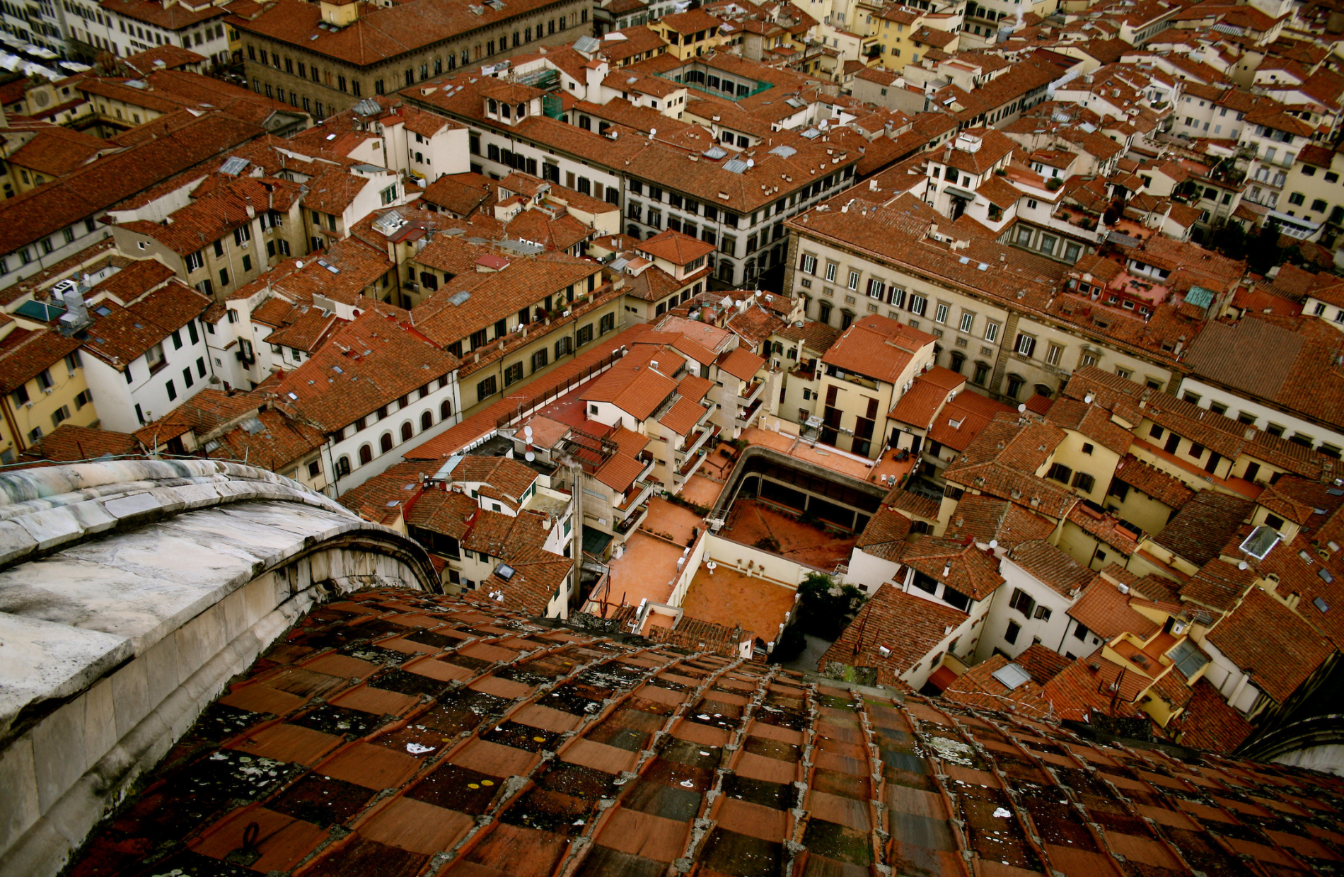 view from a tall building looking down at the red roof tops of buildings