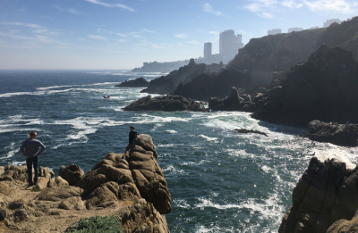 people standing on a cliff side looking at the Chilean coastline