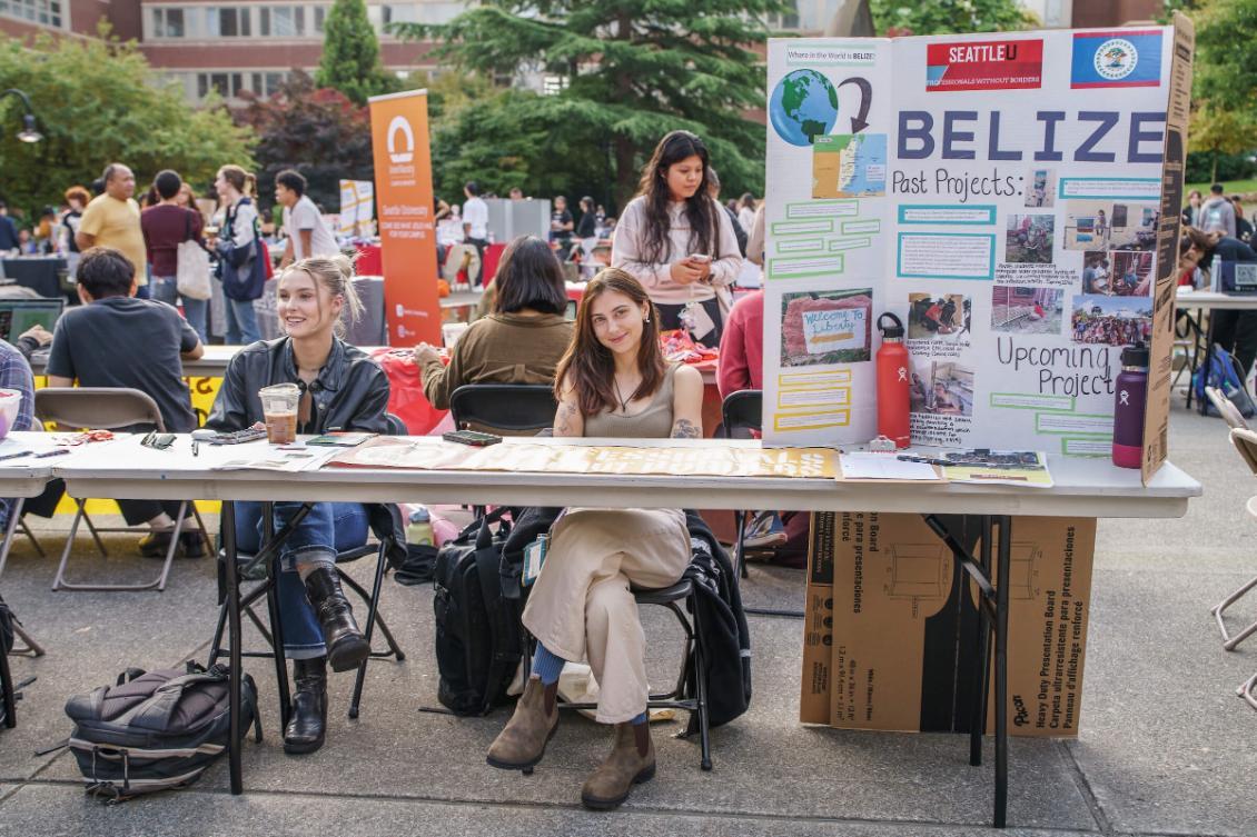 An outdoor fair with a table and two students