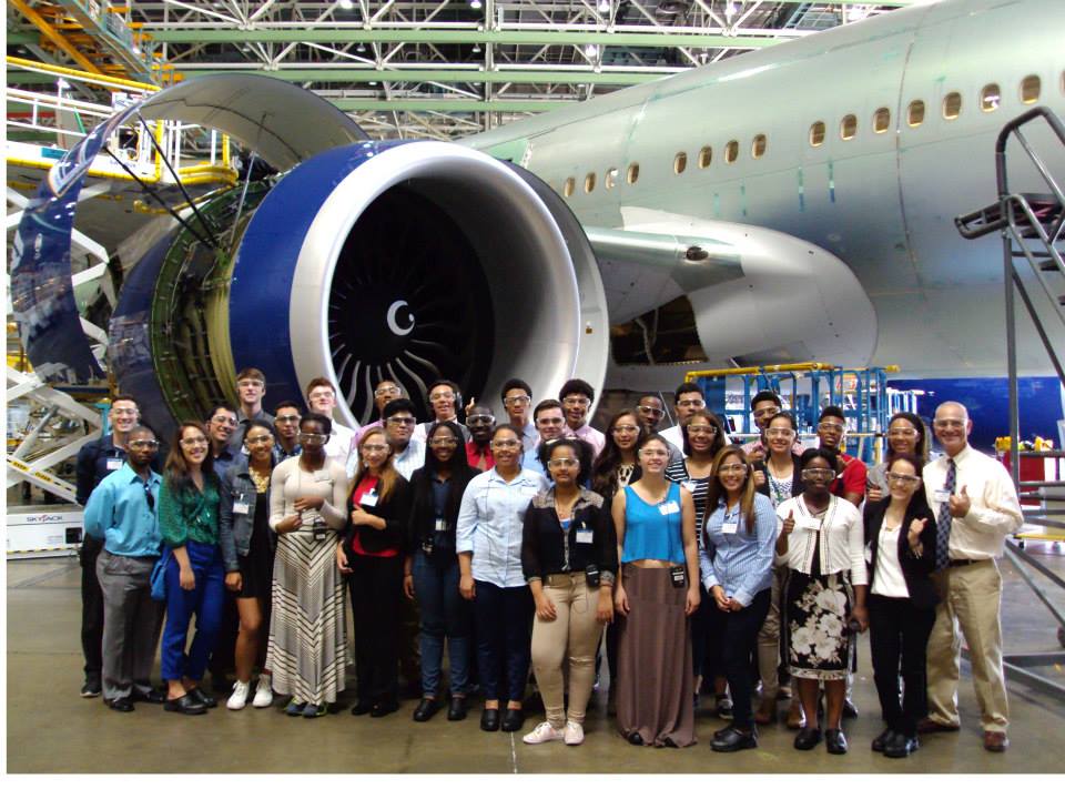 A group of students posing by a Boeing airplane