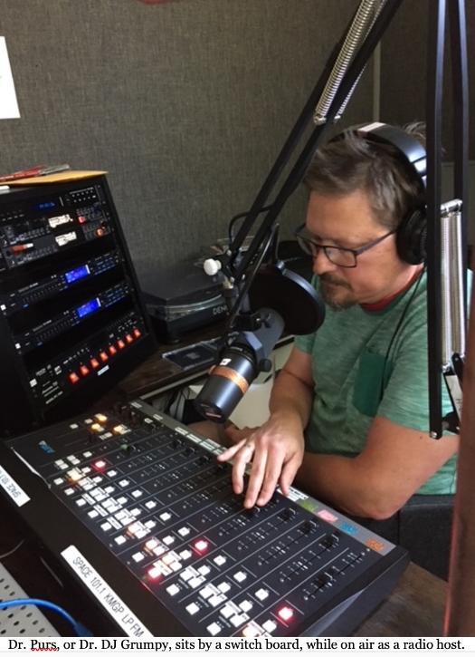 A DJ sitting at a mixing board