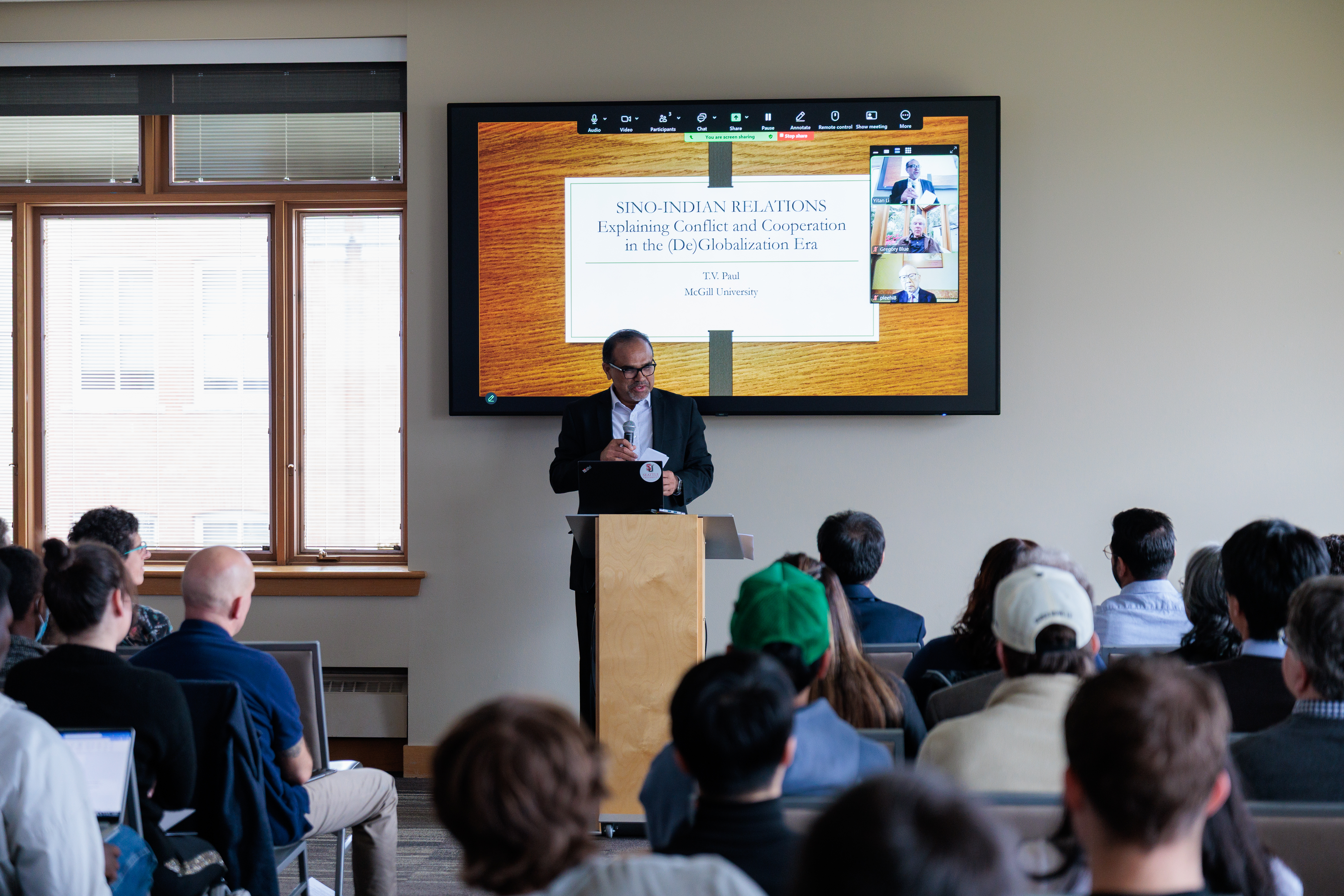 a man giving a lecture in front of an audience about china and india