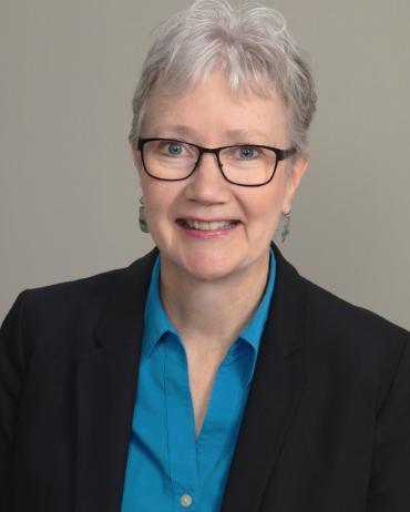 A woman wearing glasses and a blue shirt.