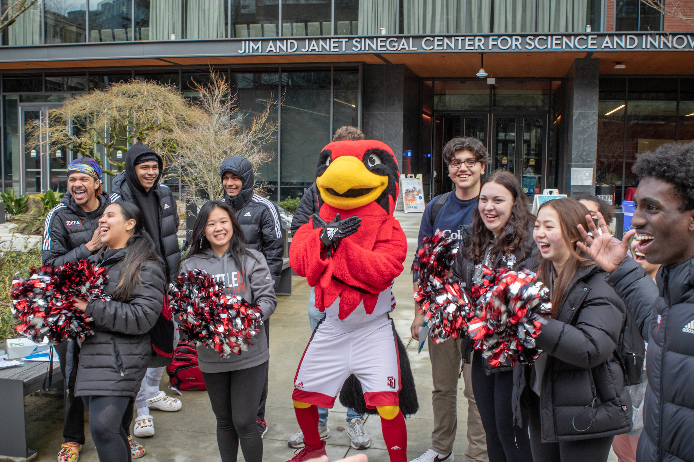 a group of students and Rudy the mascot rallying with pom-poms