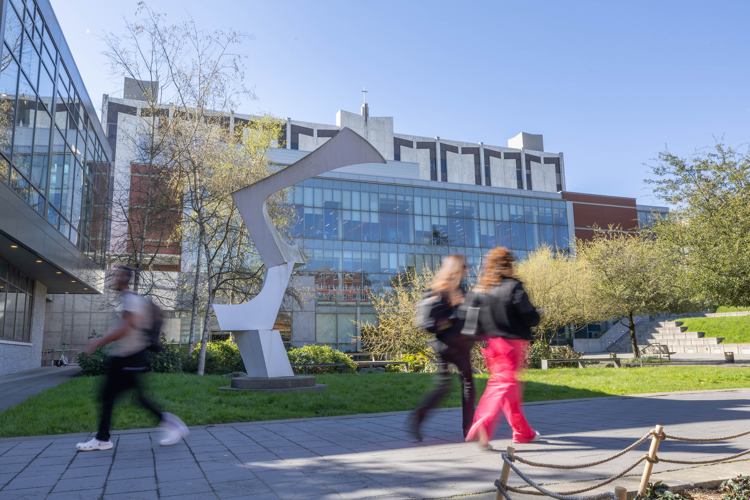 people walking by the library on a spring day