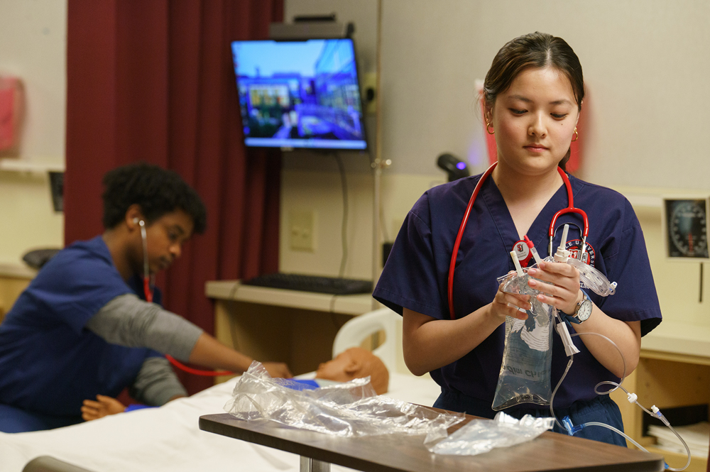 A nursing student prepares an IV