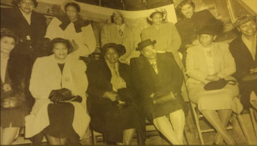 A group of people sitting in chairs, posing for a picture.