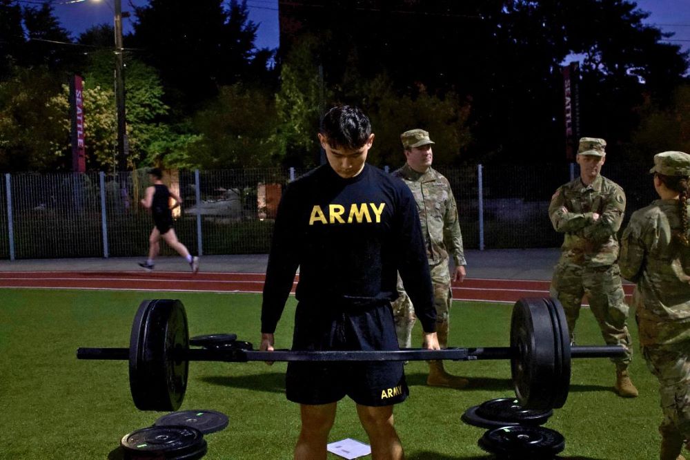 Cadet in black Army T lifting weights